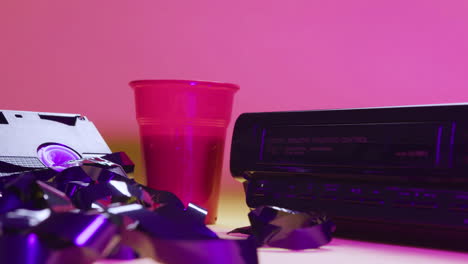 close up view of video vhs device and cassette on pink background