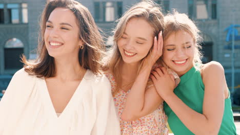 three happy women friends laughing outdoors