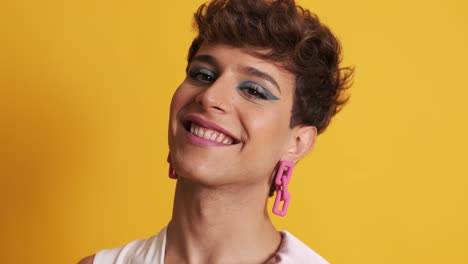 transgender man in make up posing while smiling at the camera