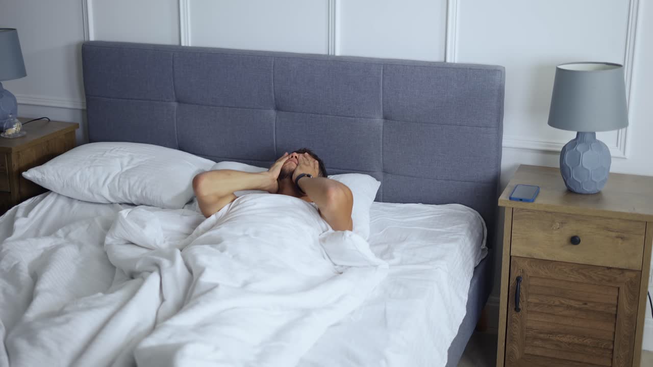 아침에 깨어나는 남자, 침실에서 침대에서 일어나는 남자