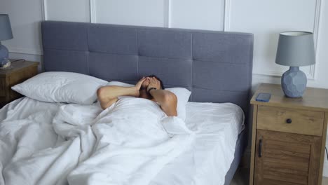 아침에 깨어나는 남자, 침실에서 침대에서 일어나는 남자