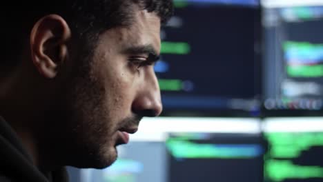 focused individual analyzing computer code in a high-tech environment, surrounded by multiple screens displaying data and programming output for enhanced problem solving