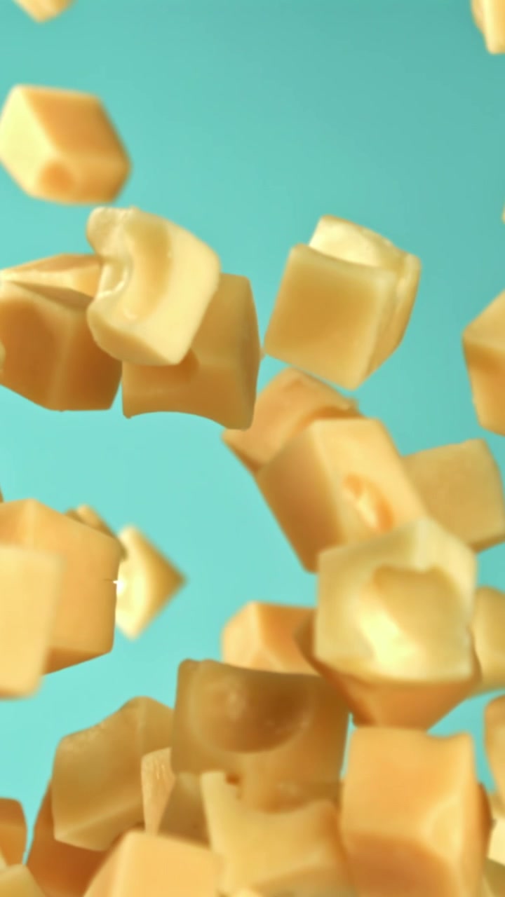 Dolci cubetti di caramello che cadono e galleggiano su sfondo blu