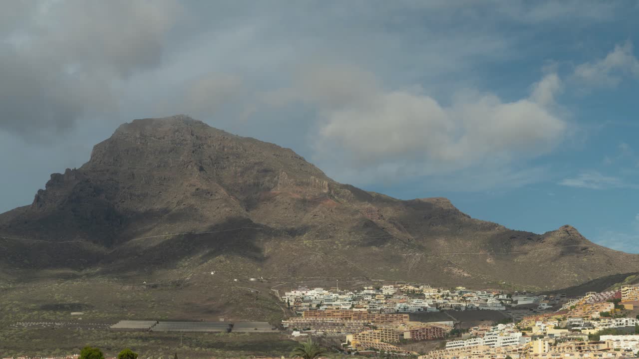 Nuvole che si estendono sulla cima della montagna nel parco nazionale del Teide sull'isola di Tenerife, con una città maestosa