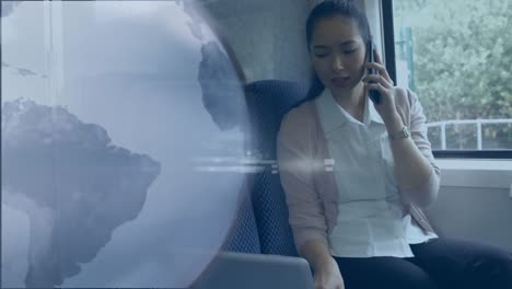 Animation-of-grey-globe-over-businesswoman-ontrain-using-laptop-and-smartphone