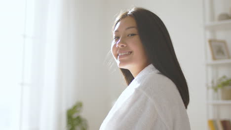 smiling young woman in a white bathrobe