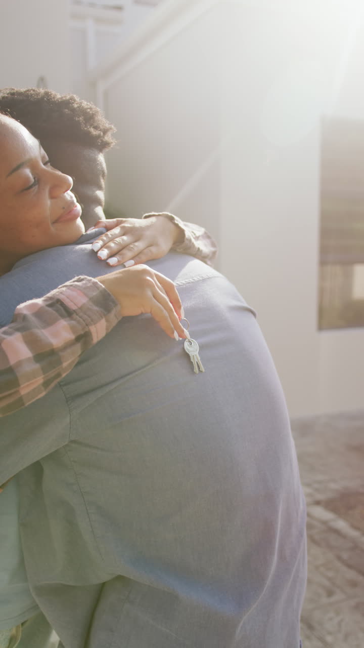 video vertical de una feliz pareja afroamericana abrazándose en casa