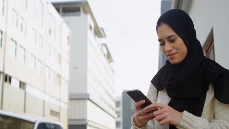Mujer-Con-Hijab-Enviando-Mensajes-De-Texto-En-La-Calle-4k