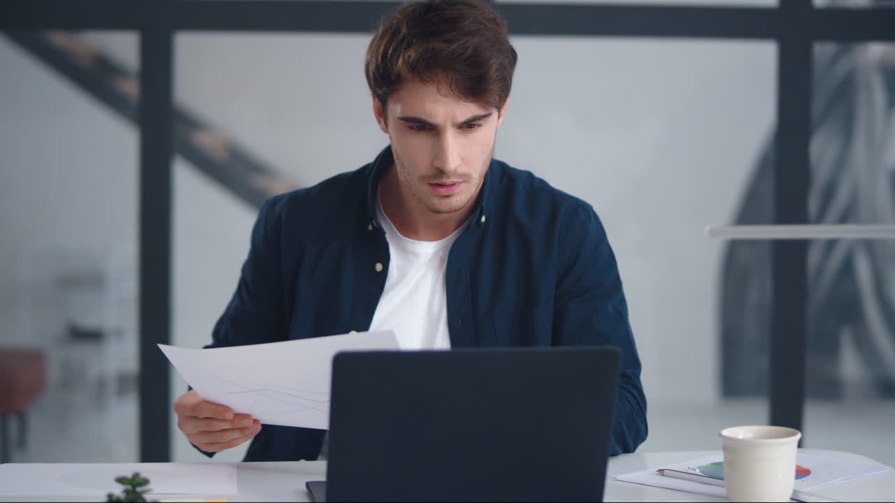 Uomo d'affari concentrato che legge attentamente un documento. Uomo concentrato che esamina i documenti.