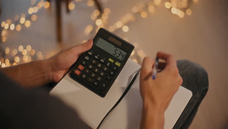 Man calculating budget sitting at home