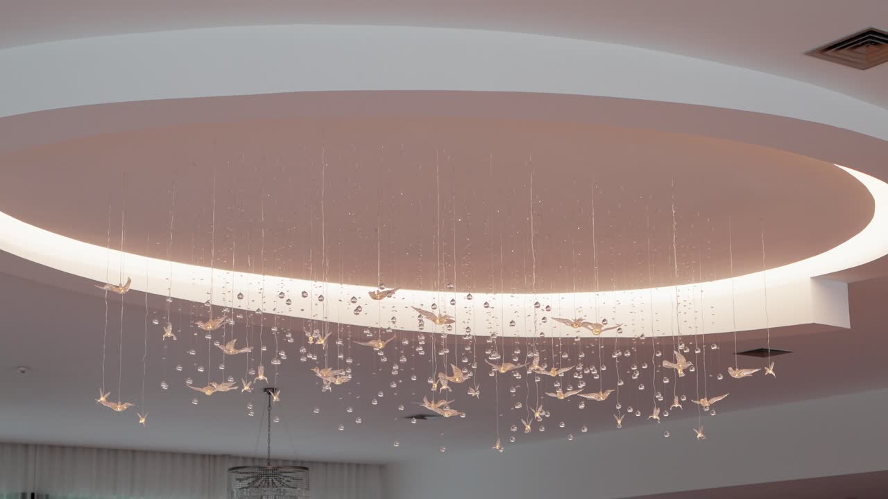 Elegant ceiling decor with hanging origami birds and crystals in a soft lit circular dome