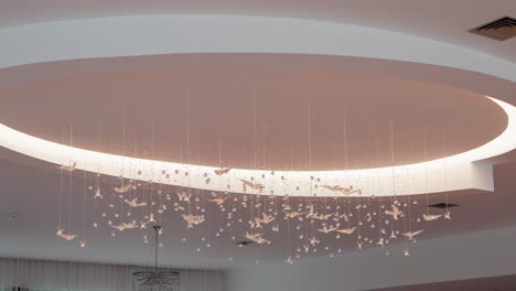 elegant ceiling decor with hanging origami birds and crystals in a soft lit circular dome