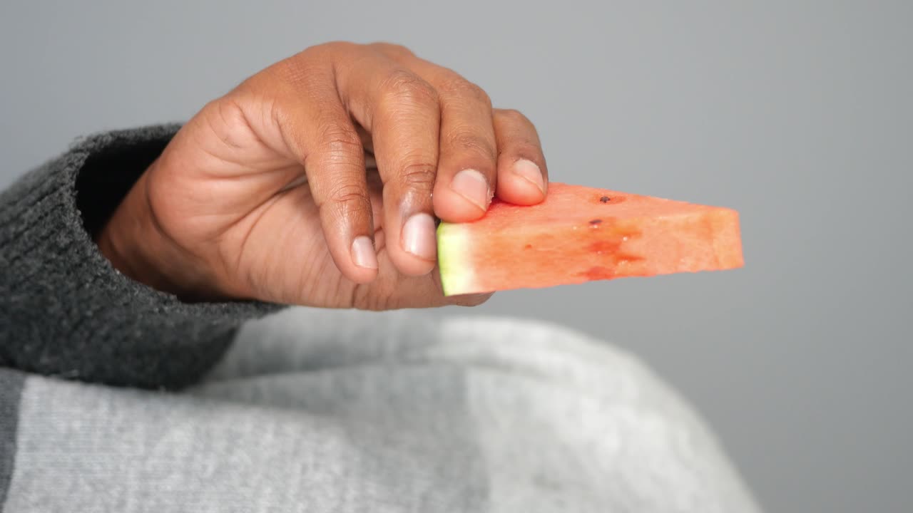 mano con una rebanada de sandía