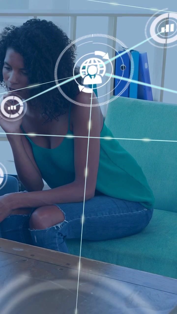 Vertical video: Woman on sofa gesturing, starting tech HUD nodes moving over torso showing data