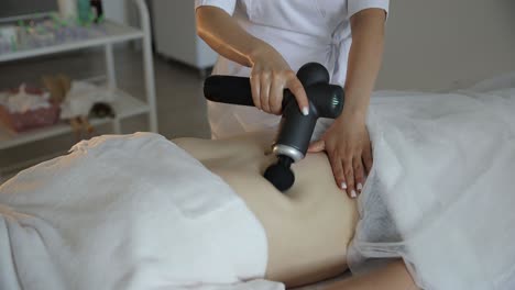 woman receiving abdominal massage with percussion therapy