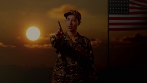 soldier pointing at sunset with american flag