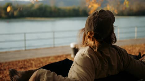 hiker sitting in front of lake looking all around exploring place, dürnstein