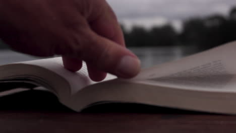 text-book-on-a-table-overlooking-a-lake