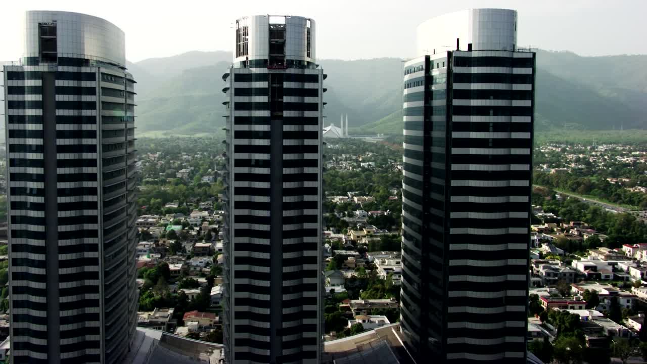 This high-resolution aerial photograph captures the Centaurus Mall complex in Islamabad, Pakistan, featuring three modern skyscrapers with curved glass facades