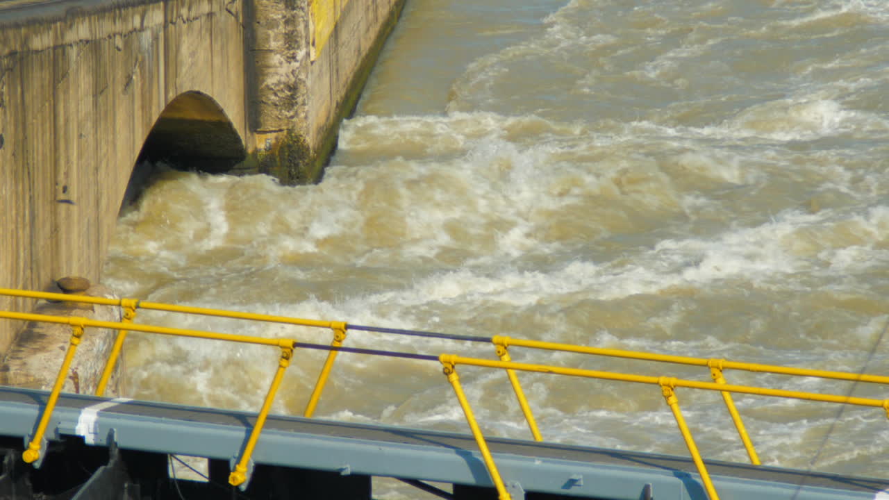 Massive water drainage in shipping canal locks with closed gates visible in foreground