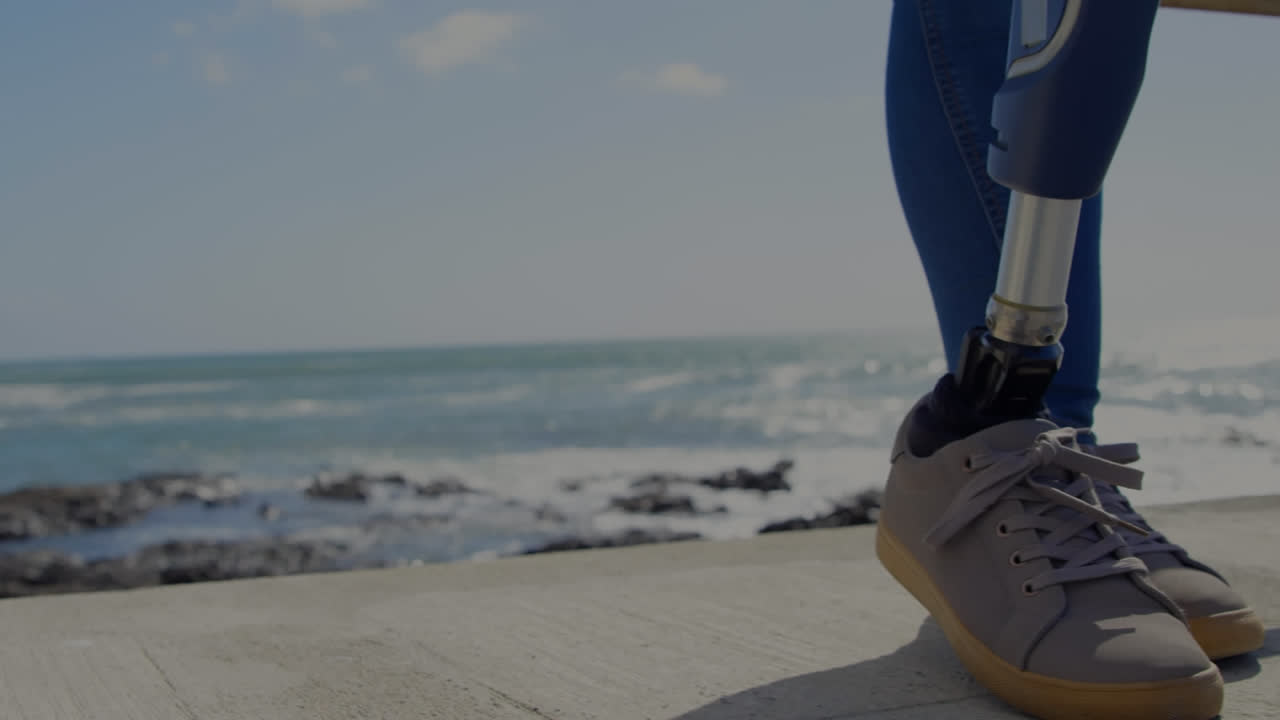 해변에 서 있는 인공 팔다리를 가진 여성 위의 스 스캔의 애니메이션