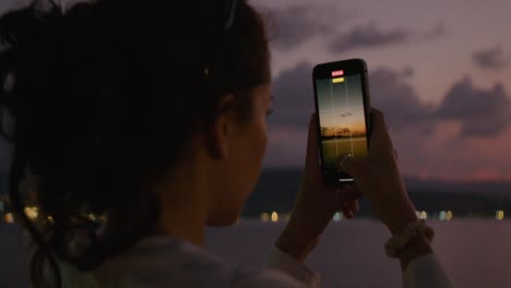 woman taking sunset photo