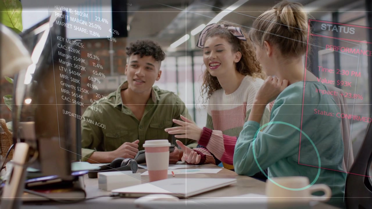 Right woman leaning and pointing at monitor, team watching, HUD charts appearing for tech review
