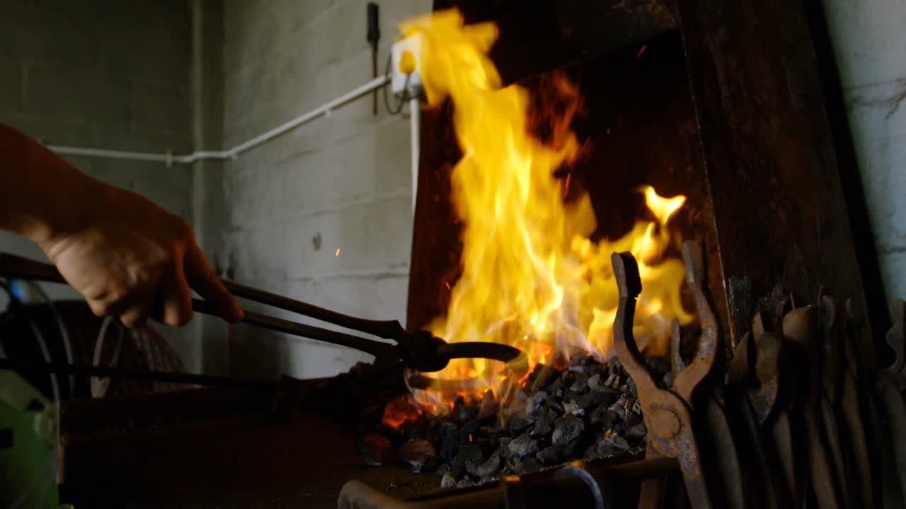 metalúrgica calentando una herradura en el fuego 4k
