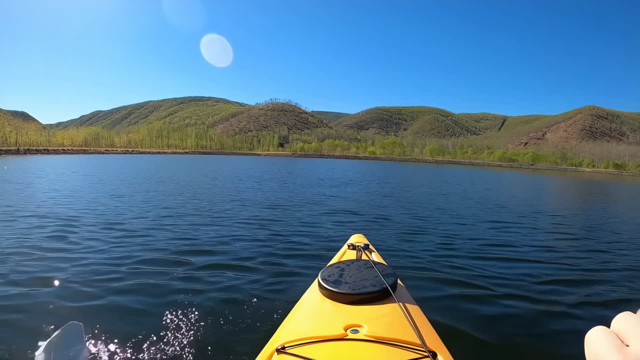 First-Person Kayaking on a Scenic Lake Surrounded by Green Hills