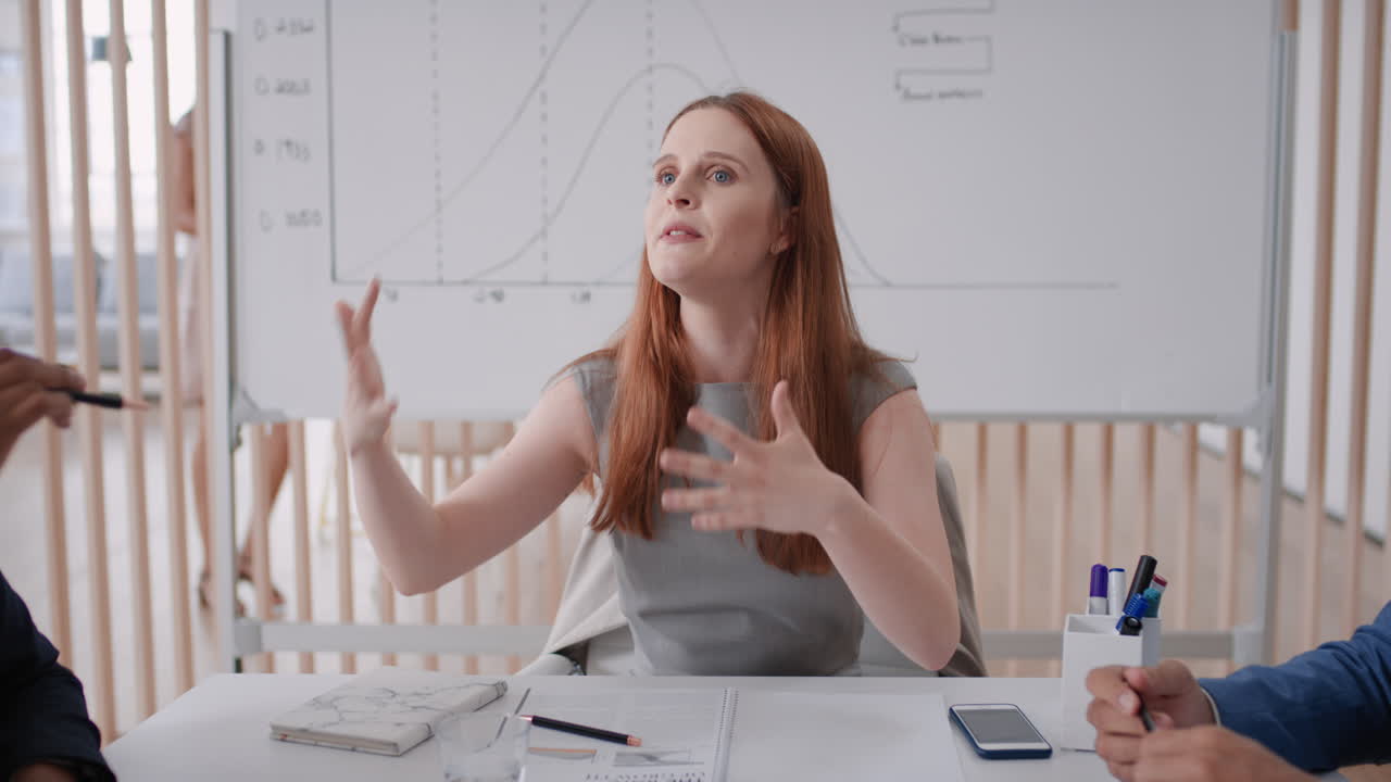 red head business woman team leader meeting with colleagues sharing creative ideas for startup project discussing corporate strategy in office boardroom