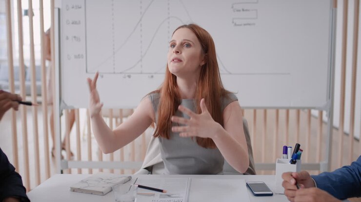 red head business woman team leader riunione con i colleghi condivisione di idee creative per il progetto di avvio discussione della strategia aziendale in ufficio boardroom