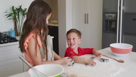 Happy-caucasian-siblings-baking-together,-preparing-cookies-in-kitchen