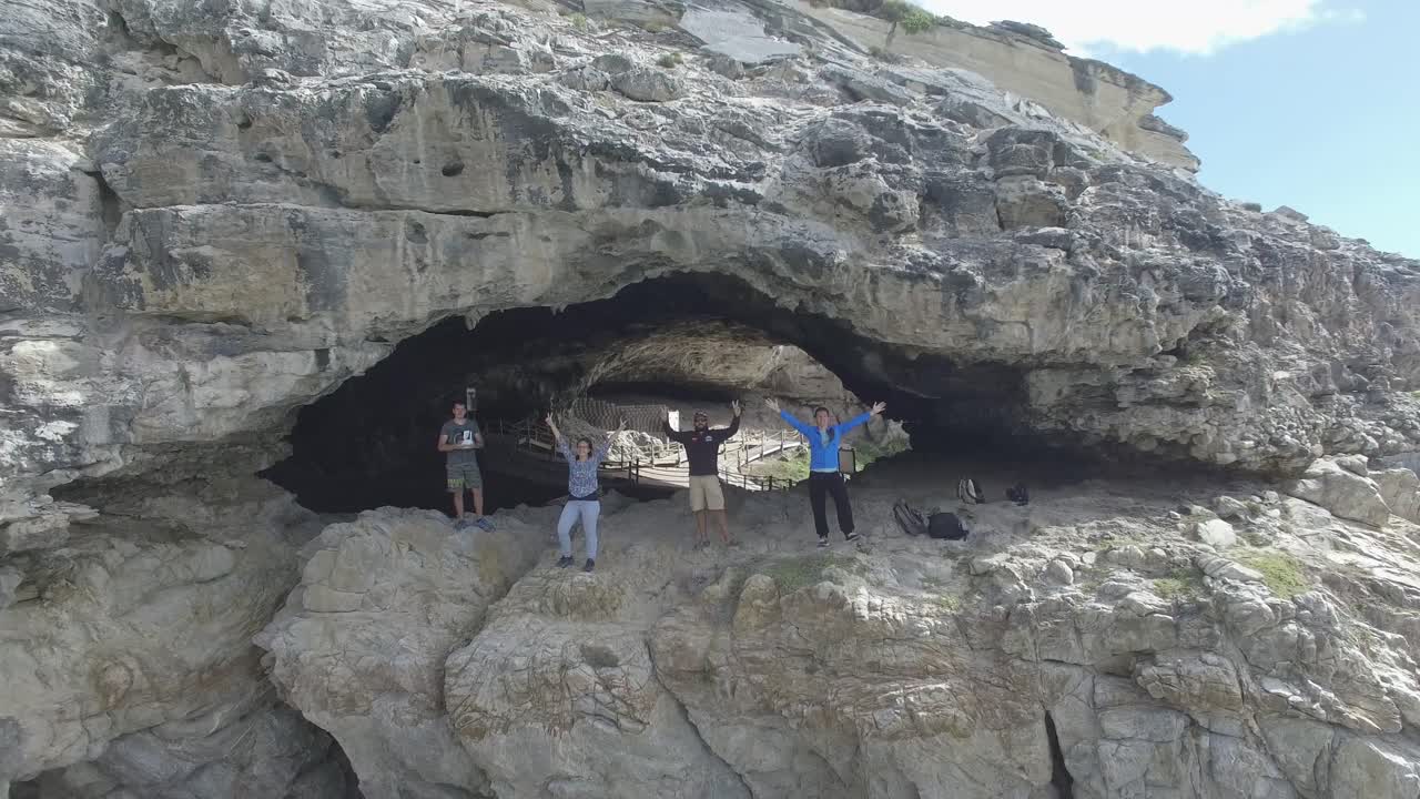 View from the air of People standing on the cliffs at Walker Bay Nature Reserve and Klipgat Cave in Gansbaai, South Africa