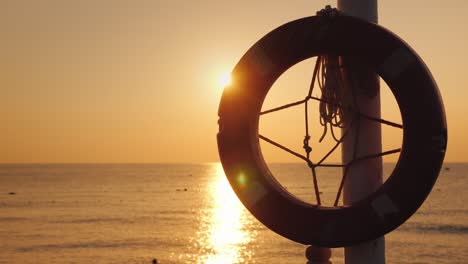 a lifeline hangs against the backdrop of the sea where the sun rises