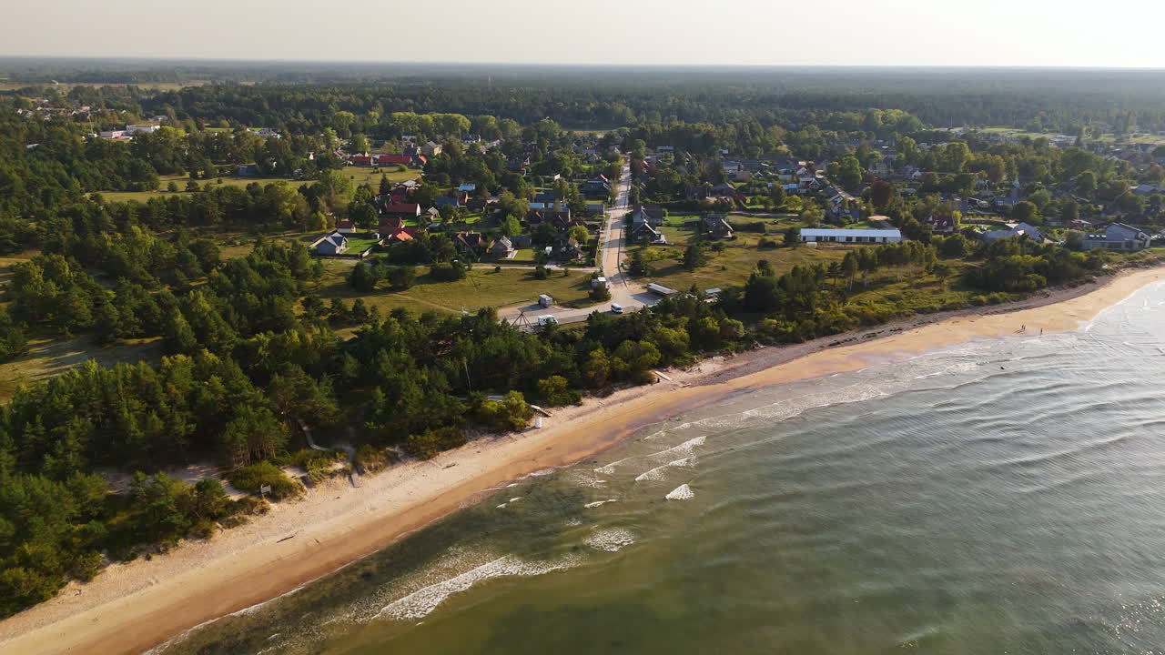 imágenes aéreas de pavilosta, letonia, con playas de arena y un paisaje urbano pintoresco.