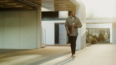 hombre de negocios caminando al aire libre con café