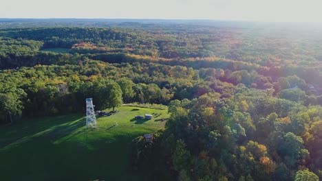 drone orbit counterclockwise of stratham fire tower in stratham, nh during golden hour in early fall