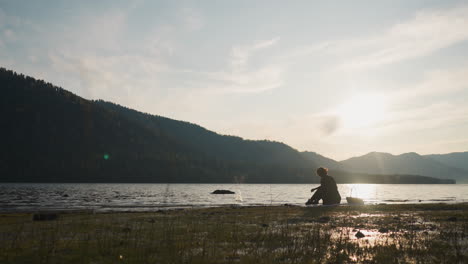 woman fishing at sunset on a lake