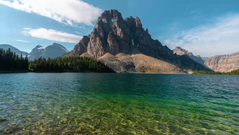 Timelapse,-Hermoso-Paisaje-De-Montaña-En-Un-Día-Soleado,-Lago-Alpino-Y-Nubes-Ligeras-Que-Se-Mueven-Sobre-Los-Picos-Del-Monte-Assiniboine,-Canadá