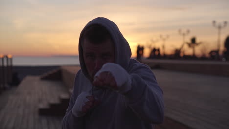 man boxing at sunset on the beach