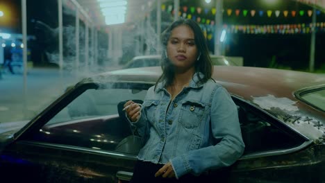woman smoking near a vintage car at night
