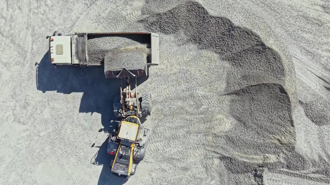 Granite quarry operation with truck and heavy machinery working on site