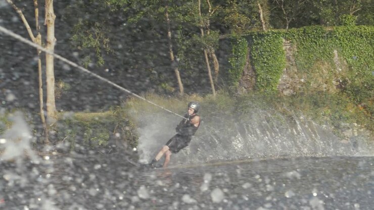 Slalom skier cutting, sending high spray in slow motion