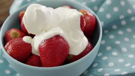 primer plano de fresas frescas con crema en el cuenco