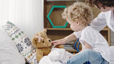 mother and toddler boy playing doctor