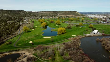 us, oregon, prineville, , 2025-04-11 - drone view of a steel pedestrian bridge at rimrock park and the crooked river at a golf course in spring in central oregon