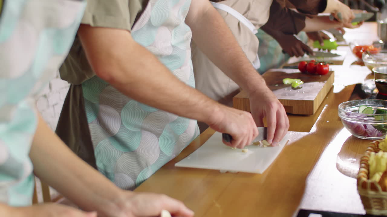 シェフと一緒に料理の授業で料理をしている多様な学生