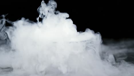 Ice-smoke-in-bowl-against-black-background-4k