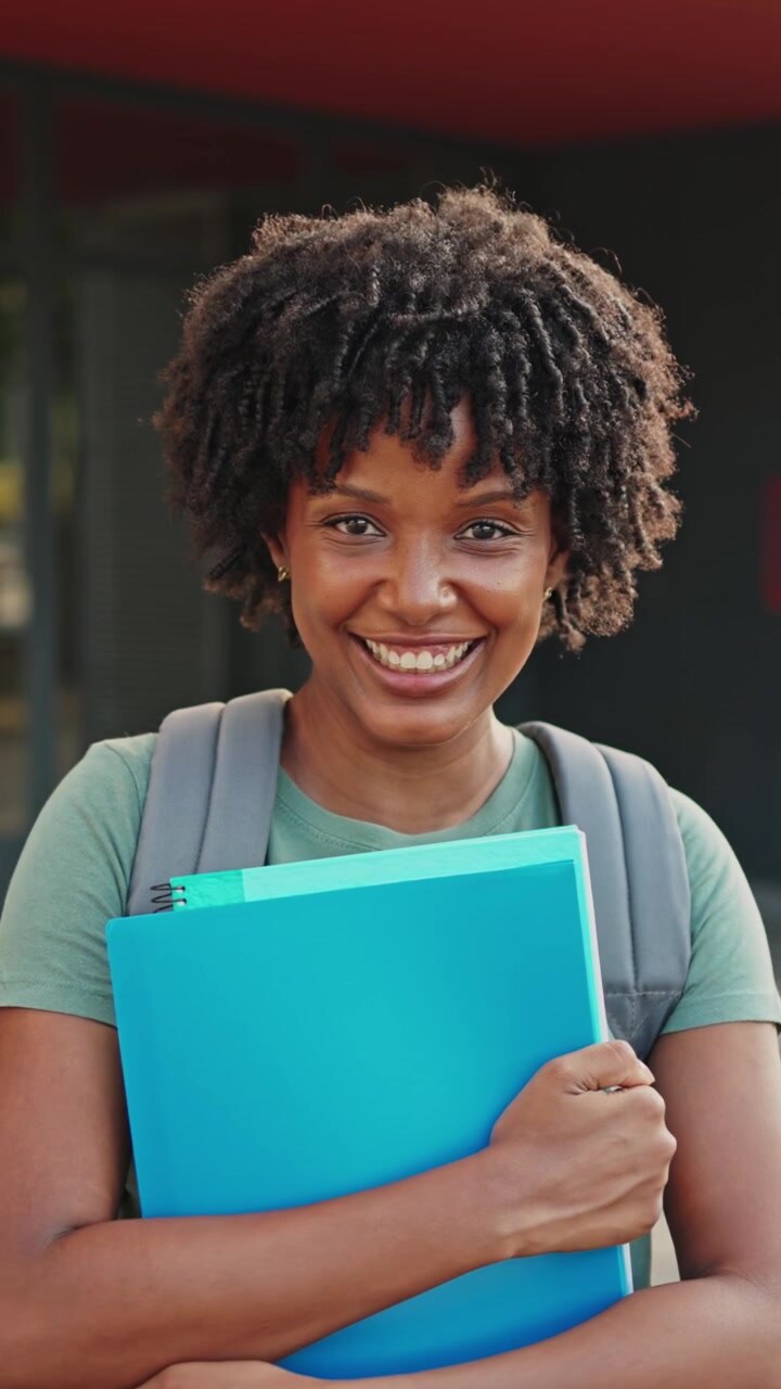 Felice giovane studentessa afroamericana che sorride alla fotocamera