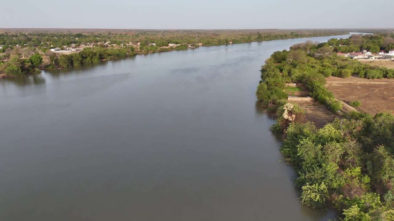Aerial footage of the Gambia River flowing between green banks, showcasing an untouched natural African landscape